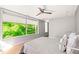 Well-lit bedroom with large windows, a comfortable bed, and modern ceiling fan at 9021 Albatross Ct, Raleigh, NC 27613