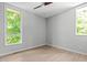 Clean, minimalist bedroom with light wood floors and two large windows at 9021 Albatross Ct, Raleigh, NC 27613
