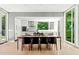 Dining room featuring modern table with black chairs, view of kitchen, and large windows at 9021 Albatross Ct, Raleigh, NC 27613