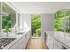 Well-lit kitchen with white countertops, stainless steel appliances, and large windows overlooking lush greenery at 9021 Albatross Ct, Raleigh, NC 27613