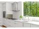 Bright kitchen with modern appliances, white cabinets, tile backsplash, and large window with wooded view at 9021 Albatross Ct, Raleigh, NC 27613