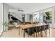 Spacious living area with a grand piano, glass staircase, and floor-to-ceiling windows at 9021 Albatross Ct, Raleigh, NC 27613