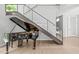 Bright living room featuring a piano, wood floors and modern staircase with glass railing at 9021 Albatross Ct, Raleigh, NC 27613