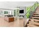 Bright living room with modern fireplace, hardwood floors, large windows, and sleek staircase at 9021 Albatross Ct, Raleigh, NC 27613