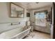 Bathroom featuring a clawfoot tub, toilet, window, and cracked walls at 903 Nicholas St, Henderson, NC 27536