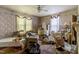 Overstuffed bedroom with floral wallpaper and several windows at 903 Nicholas St, Henderson, NC 27536