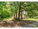 Home partially obscured by lush trees, hinting at a private and natural setting at 903 Nicholas St, Henderson, NC 27536