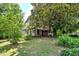 Traditional home with a covered porch, set amongst mature trees and a lush front lawn at 903 Nicholas St, Henderson, NC 27536