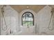 Spacious bathroom with a soaking tub by an arched window, marbled walls, and gold fixtures at 913 Tyrrell Rd, Raleigh, NC 27609