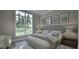 Sunlit bedroom with large window and light gray decor and modern furnishings at 913 Tyrrell Rd, Raleigh, NC 27609