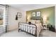 Bedroom with an olive green accent wall, iron bed frame, and neutral-colored decor at 1021 Dillon Lake Dr, Knightdale, NC 27545