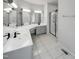 Bathroom with a double sink vanity, large mirrors, a tiled floor, and a glass-enclosed shower at 105 Crosswaite Way, Cary, NC 27518