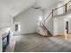 Bright living room showcasing vaulted ceilings, a cozy fireplace, and elegant staircase with a wood banister and white risers at 105 Crosswaite Way, Cary, NC 27518