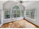 Bright sunroom featuring hardwood floors, large windows, and a vaulted ceiling with a ceiling fan at 105 Crosswaite Way, Cary, NC 27518