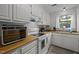 Cozy kitchen with wooden countertops, white cabinets, standard appliances, and a window with a view at 105 Fidelity St # B19, Carrboro, NC 27510