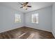 Bedroom featuring wood-look floors, two windows, and a modern ceiling fan at 1195 Champion Dr, Cary, NC 27511