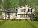 Charming split-level home with a well-manicured lawn and mature trees providing ample shade at 1195 Champion Dr, Cary, NC 27511