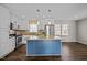 Bright kitchen features white cabinets, stainless steel appliances, a granite island, and stylish pendant lighting at 1195 Champion Dr, Cary, NC 27511