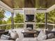 Cozy covered porch with a stone fireplace, wood ceiling, and peaceful wooded views at 121 Anfield Rd, New Hill, NC 27562