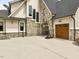 Exterior view of the home's side entry garage with a basketball hoop and stone accents at 121 Anfield Rd, New Hill, NC 27562