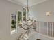 Second floor landing features views of the lush exterior and a stylish modern chandelier at 121 Anfield Rd, New Hill, NC 27562