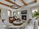 Cozy living room with fireplace, wood beams, comfortable seating, and abundant natural light at 121 Anfield Rd, New Hill, NC 27562