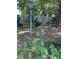 View of wooded backyard with a lightpost, fence, and a discarded loveseat at 1403 S Roxboro Street, Durham, NC 27703