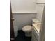 Bathroom featuring standard white toilet, sink, and built-in shelving against block wall at 1403 S Roxboro Street, Durham, NC 27703