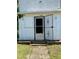 Front view of house entrance featuring weathered, white siding and secure black security door at 1403 S Roxboro Street, Durham, NC 27703