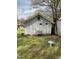 A side-view of a weathered outbuilding with an air conditioner, in a yard with lush ground cover at 1403 S Roxboro Street, Durham, NC 27703