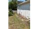 Side yard view of white home with weathered paint along brick and stone pathway to fenced-in yard at 1403 S Roxboro Street, Durham, NC 27703