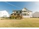 Large backyard featuring a spacious lawn, wooden deck, and meticulously landscaped flower bed at 1475 Sierra Glen Cir, Apex, NC 27502
