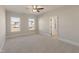 Large bedroom with carpet, ceiling fan, and a view of the exterior from the windows at 1475 Sierra Glen Cir, Apex, NC 27502
