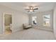 Bright bedroom with a cozy seating area and views of the neighborhood from the windows at 1475 Sierra Glen Cir, Apex, NC 27502