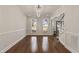 Bright dining room with hardwood floors and a modern chandelier, offering a glimpse of the outdoors through large windows and backyard at 1475 Sierra Glen Cir, Apex, NC 27502