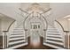 Elegant foyer featuring a grand double staircase, chandelier, and hardwood floors at 1475 Sierra Glen Cir, Apex, NC 27502