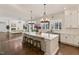 Bright, open kitchen with a large island, pendant lighting, and views to living space with hardwood floors throughout at 1475 Sierra Glen Cir, Apex, NC 27502