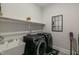 Well-equipped laundry room with modern washer, dryer, sink, shelving, and trendy decor at 1475 Sierra Glen Cir, Apex, NC 27502