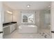 Luxurious main bathroom features a soaking tub, separate vanities, and a glass enclosed shower at 1475 Sierra Glen Cir, Apex, NC 27502