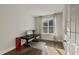 Bright home office with a dark wood desk, hardwood floors, a red phone booth, and a window with natural light at 1475 Sierra Glen Cir, Apex, NC 27502