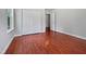 Bedroom with hardwood floors, white trim, window, double-door closet and open doorway to the hall at 148 Daneborg Rd, Durham, NC 27703
