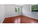 This bedroom features hardwood floors and two windows providing ample natural light and backyard views at 148 Daneborg Rd, Durham, NC 27703