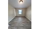 This bedroom features neutral paint colors, wood-look floors, and a single window for natural light at 1602 Fairground Rd, Dunn, NC 28334