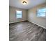 This bedroom features neutral paint colors, wood-look floors, and natural light through the windows at 1602 Fairground Rd, Dunn, NC 28334
