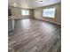 Open-concept living room features wood-look floors, neutral paint, and lots of natural light at 1602 Fairground Rd, Dunn, NC 28334