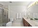 Well-lit bathroom featuring double sinks, shower, and neutral tile at 1609 Forest Rd, Wake Forest, NC 27587
