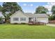 Charming single-story home featuring a ramp to the front door, complemented by lush green lawn and mature trees at 1609 Forest Rd, Wake Forest, NC 27587