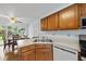 Functional kitchen featuring wood cabinets, stainless steel sink, and a view into the adjacent dining area at 1609 Forest Rd, Wake Forest, NC 27587