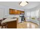 Bright kitchen featuring oak cabinets, stainless appliances, eat-in counter, and ample counter space near bay window at 1609 Forest Rd, Wake Forest, NC 27587