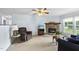 Inviting living room featuring a stone fireplace, comfortable seating, and natural light from a large window at 1609 Forest Rd, Wake Forest, NC 27587
